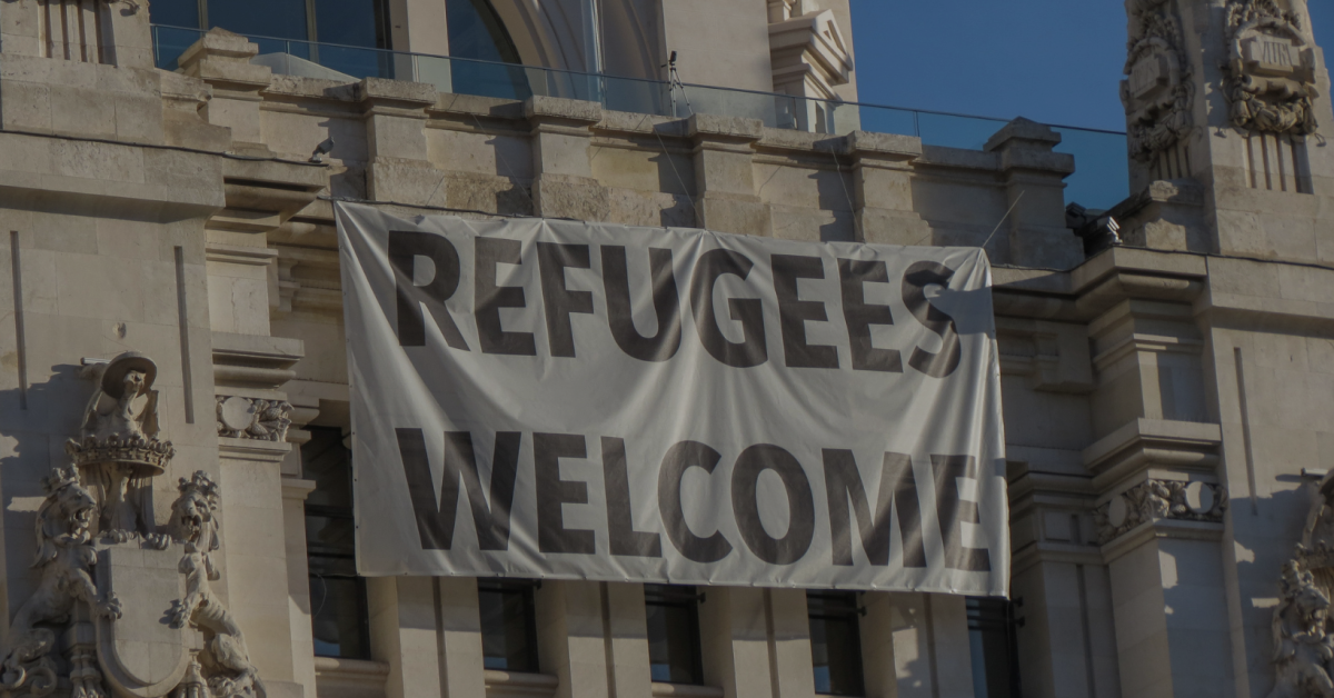 Refugees welcome sign hung from a building.