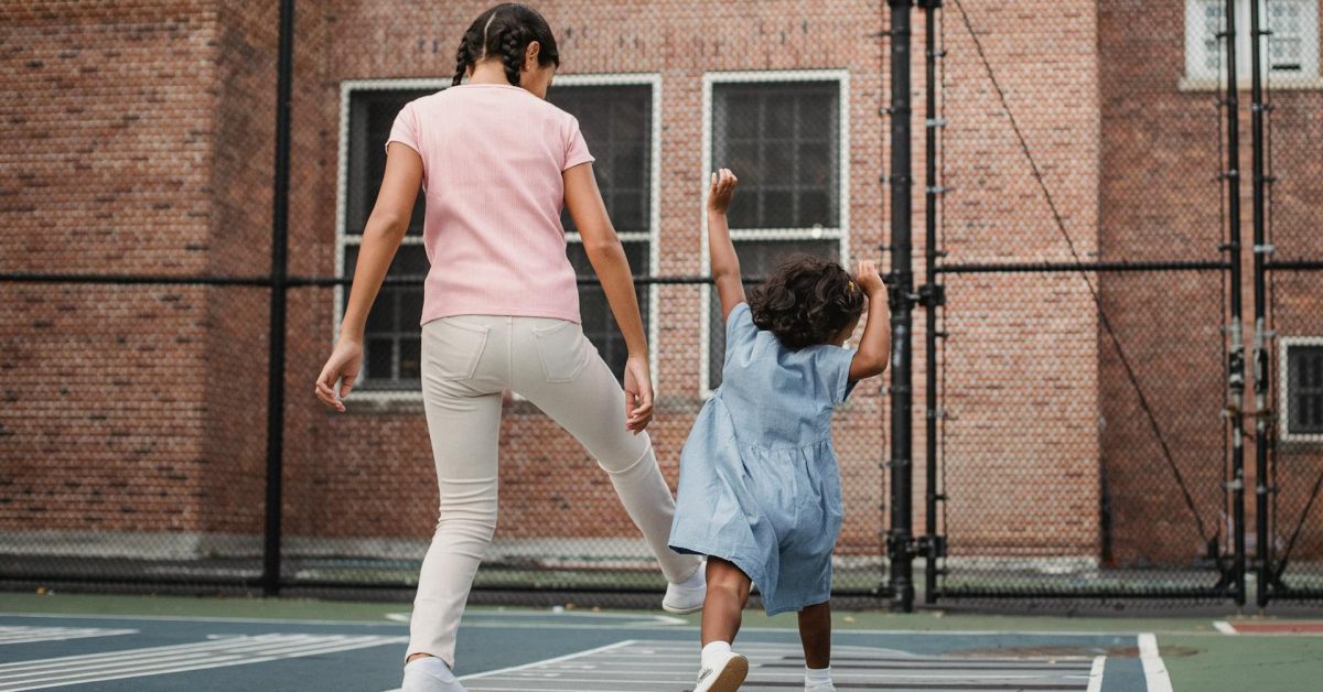 Two children jumping in a school playground