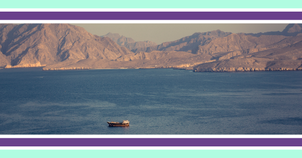 A ship on water with a mountainous backdrop, in the strait of Hormuz